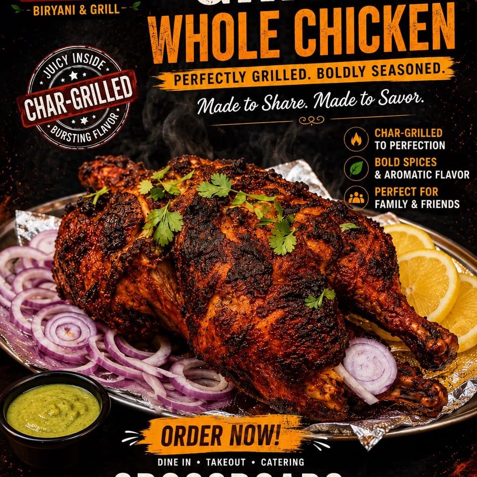 Crossroads Biryani & Grill's char-grilled whole chicken, garnished with cilantro, red onions, and lemon slices.